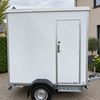 Mobiele badkamer op aanhanger Buitenzijde van mobiele badkamer op aanhanger met eigen toegangsdeur