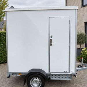 Buitenzijde van mobiele badkamer op aanhanger met eigen toegangsdeur
