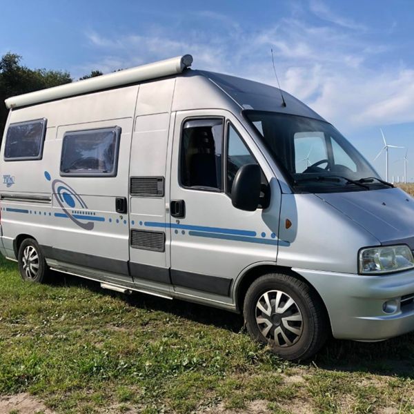 Adria Twin 2004 – buitenkant Adria Twin buscamper uit 2004, gezien vanaf de zijkant en achterzijde