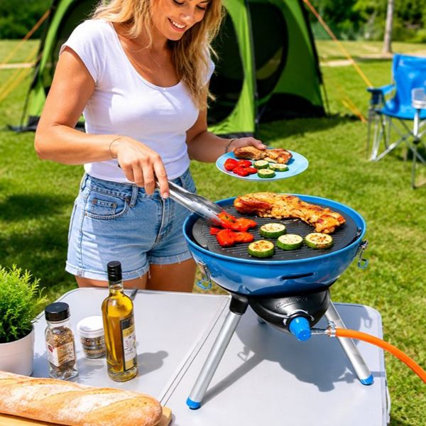 Campingaz gasbarbecue huren Persoon die buiten kookt op een Campingaz gasbarbecue tijdens een kampeervakantie.