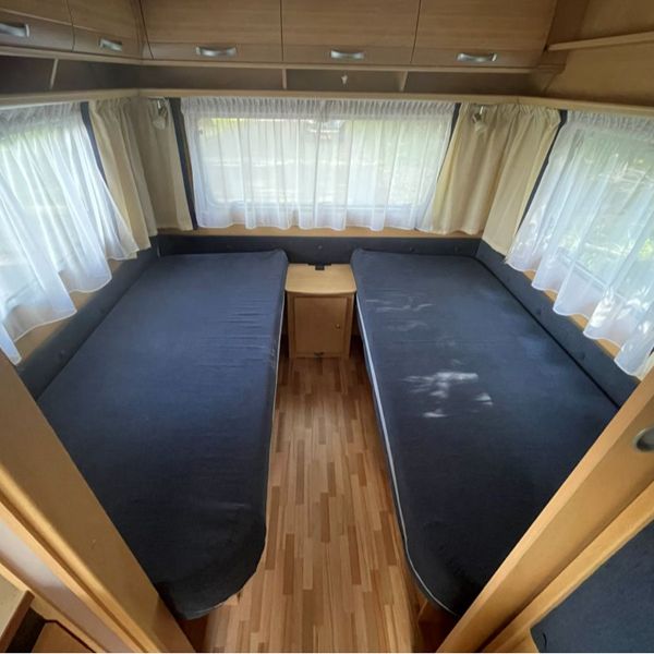 Twee enkele bedden in de Dethleffs caravan Twee comfortabele enkele lengtebedden met bovenkasten