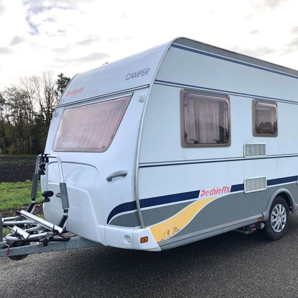 Zijkant van Dethleffs caravan met grote ramen en opbergruimte, ideaal voor vakantie