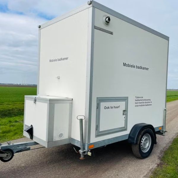 Mobiele badkamer aanhanger buitenzijde Mobiele badkamer op aanhanger van buiten gezien op locatie