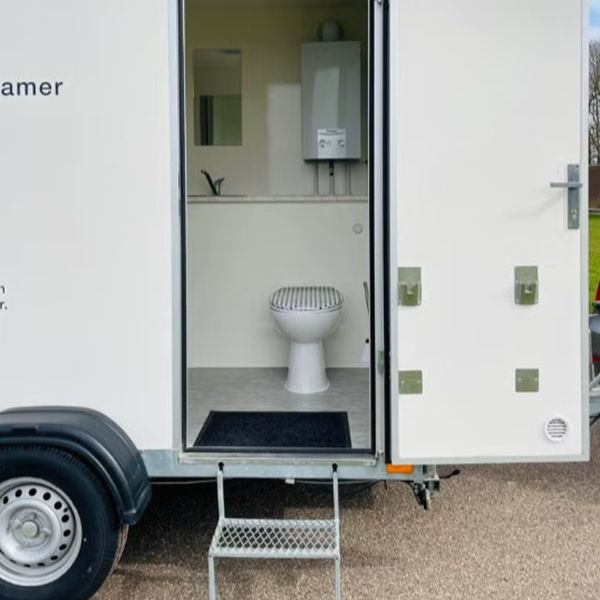 Mobiele badkamer ingang met toilet en wastafel Ingang van mobiele badkamer met toilet en wastafel op aanhanger