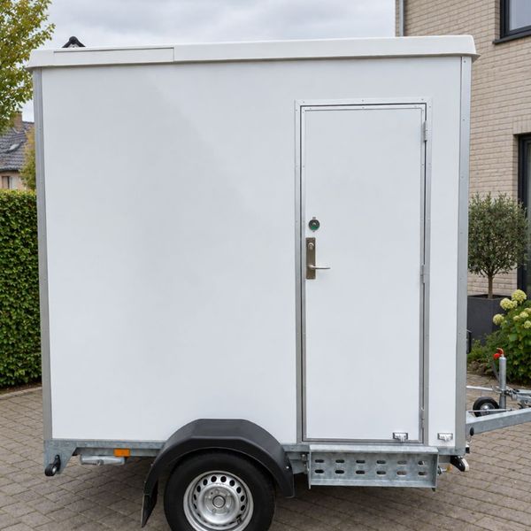 Mobiele badkamer op aanhanger Buitenzijde van mobiele badkamer op aanhanger met eigen toegangsdeur