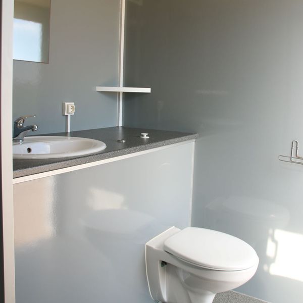 Toilet en wastafel Binnenzijde van mobiele badkamer met toilet, wastafel en spiegel