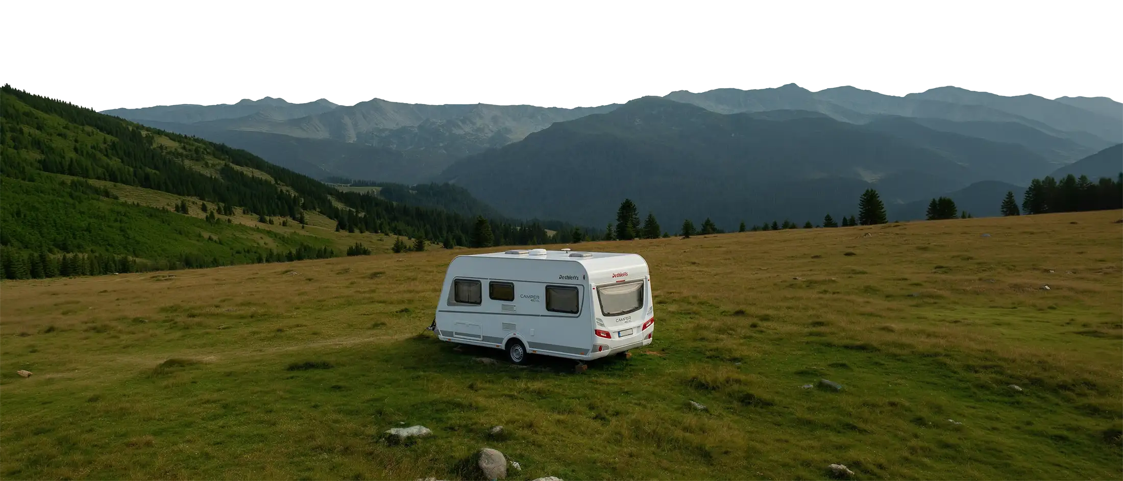 Caravan op een bergweide in een rustige bergachtige omgeving 